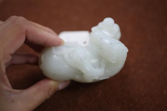 A Chinese white jade carving of two monkeys clambering on a recumbent horse, 20th century, 9cm, wood stand